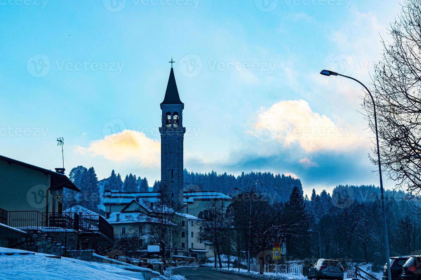 villaggio blu con nuvole e una chiesa foto
