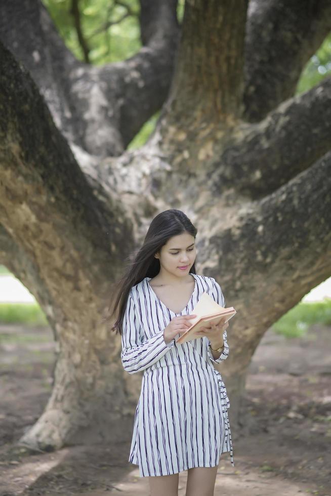 donna attraente che legge un libro nel parco foto