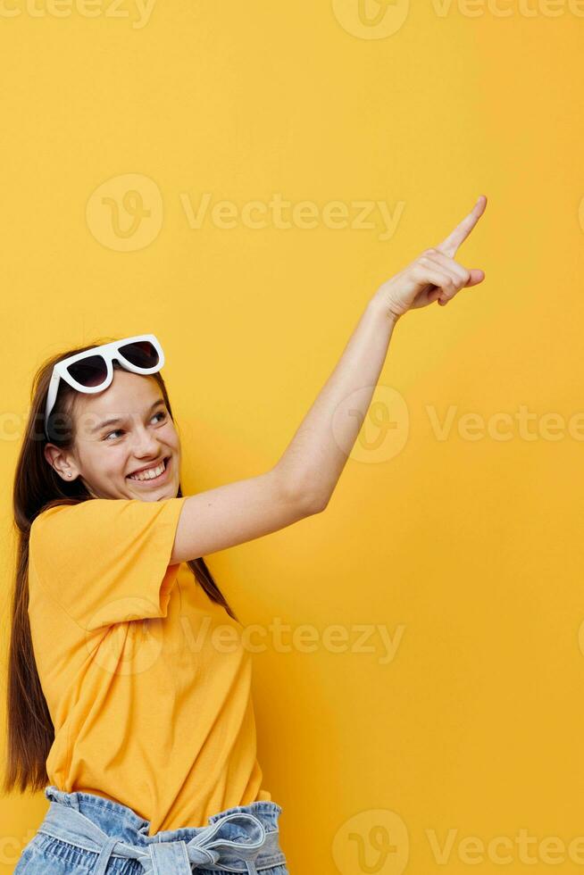 giovane donna moda nel giallo maglietta denim pantaloncini giallo sfondo foto