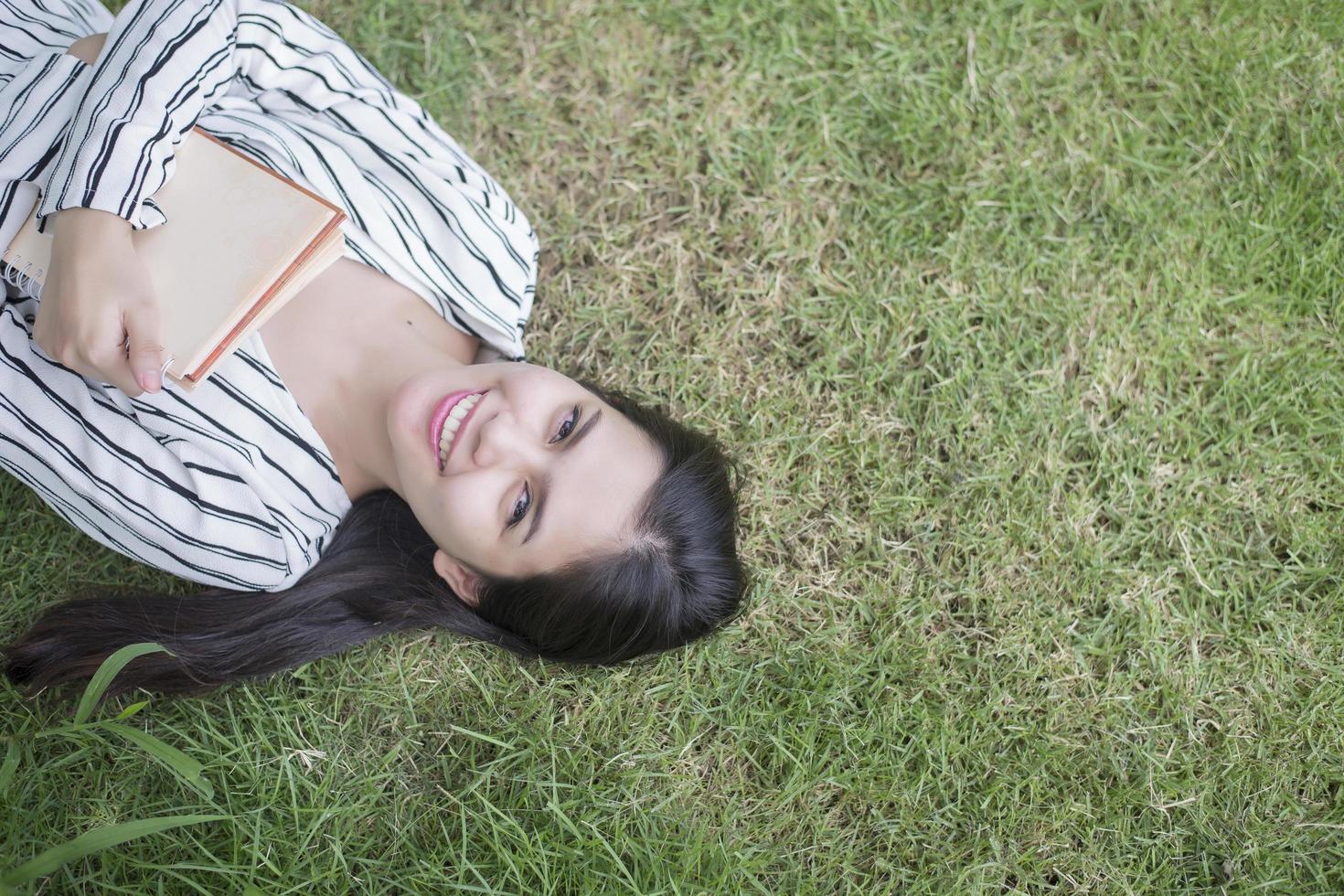 donna attraente che legge un libro nel parco foto