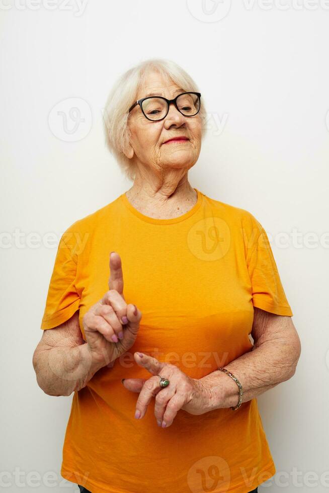 foto di pensionato vecchio signora nel casuale maglietta e bicchieri avvicinamento