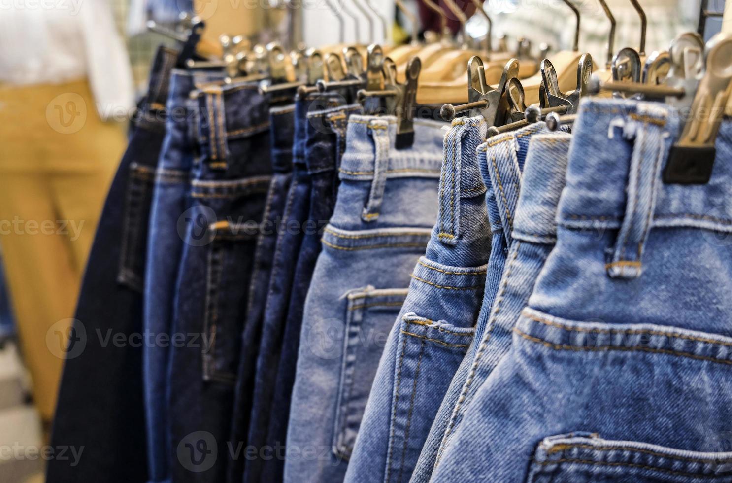 fila di gonne di jeans blu impiccati in negozio foto