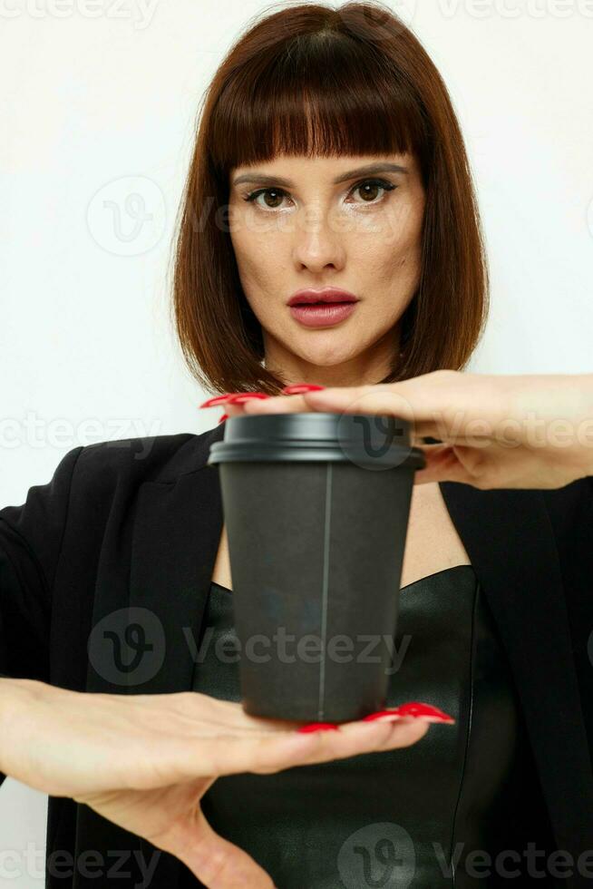 bellissimo donna nel un' nero completo da uomo un' boccale con un' bevanda fascino stile di vita inalterato foto