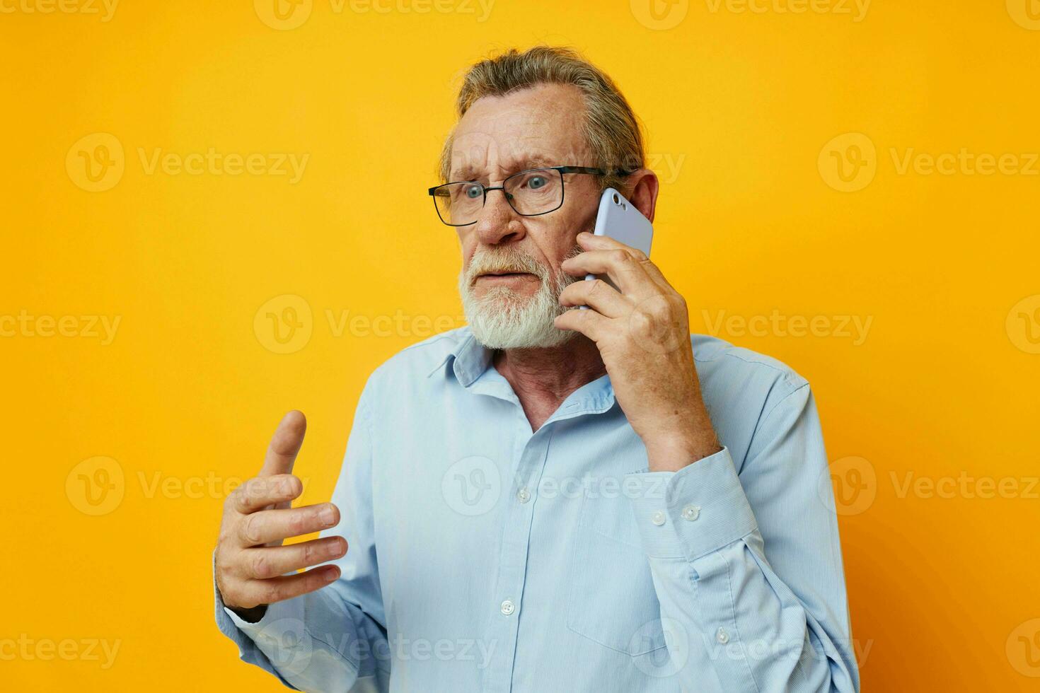 ritratto anziano uomo grigio barba con bicchieri parlando su il Telefono inalterato foto