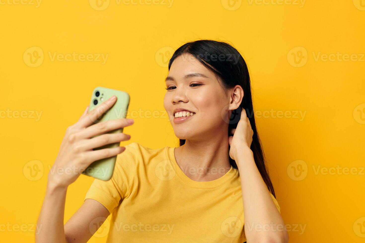 ritratto asiatico bellissimo giovane donna con un' Telefono nel sua mani fa un' autoscatto isolato sfondo inalterato foto