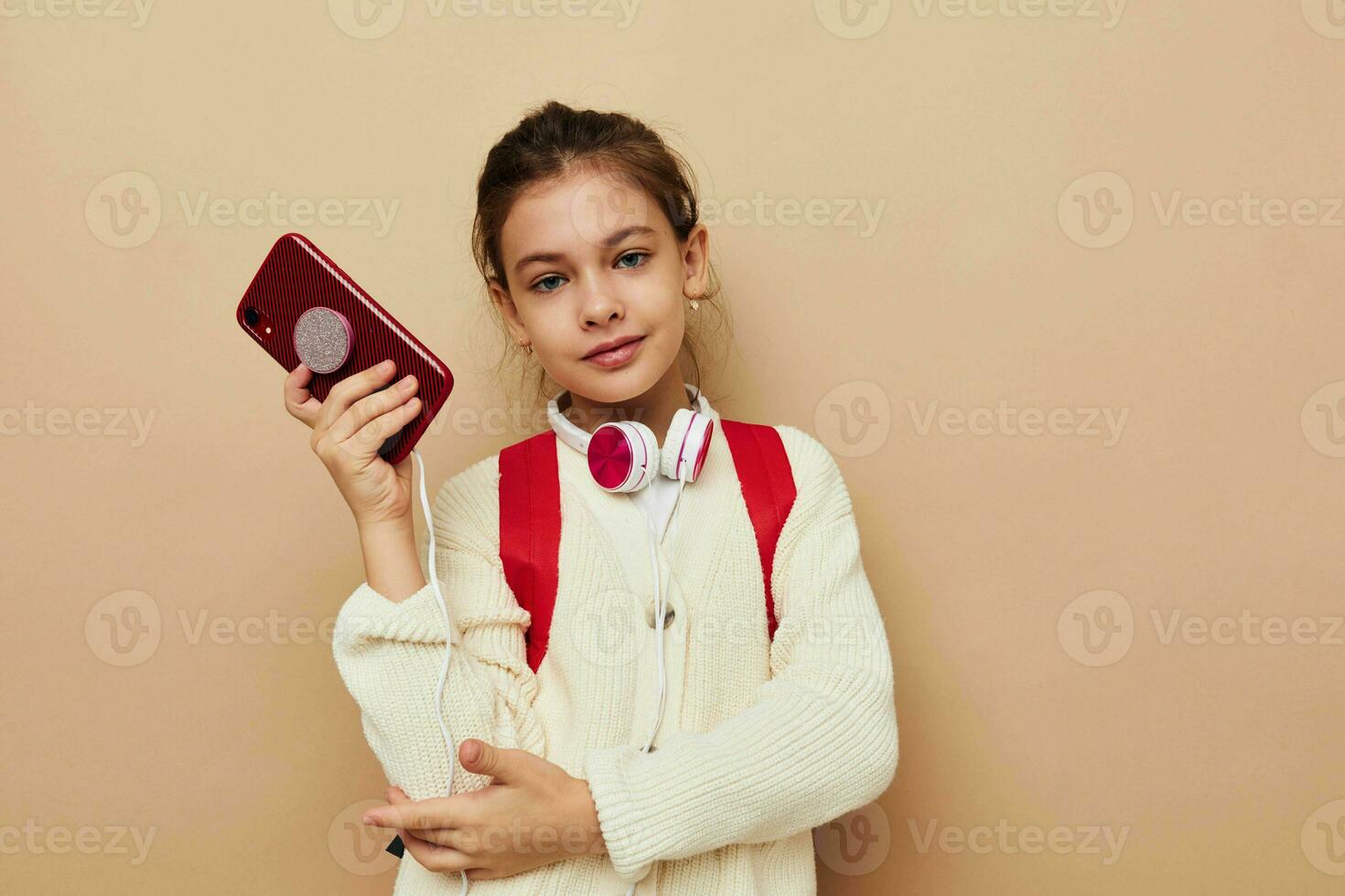 poco ragazza con Telefono in posa rosso zaino infanzia inalterato foto