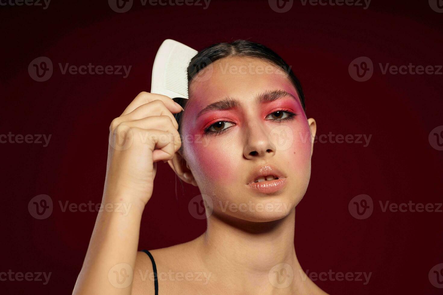 attraente donna con luminosa trucco pettinatura sua capelli personale cura foto