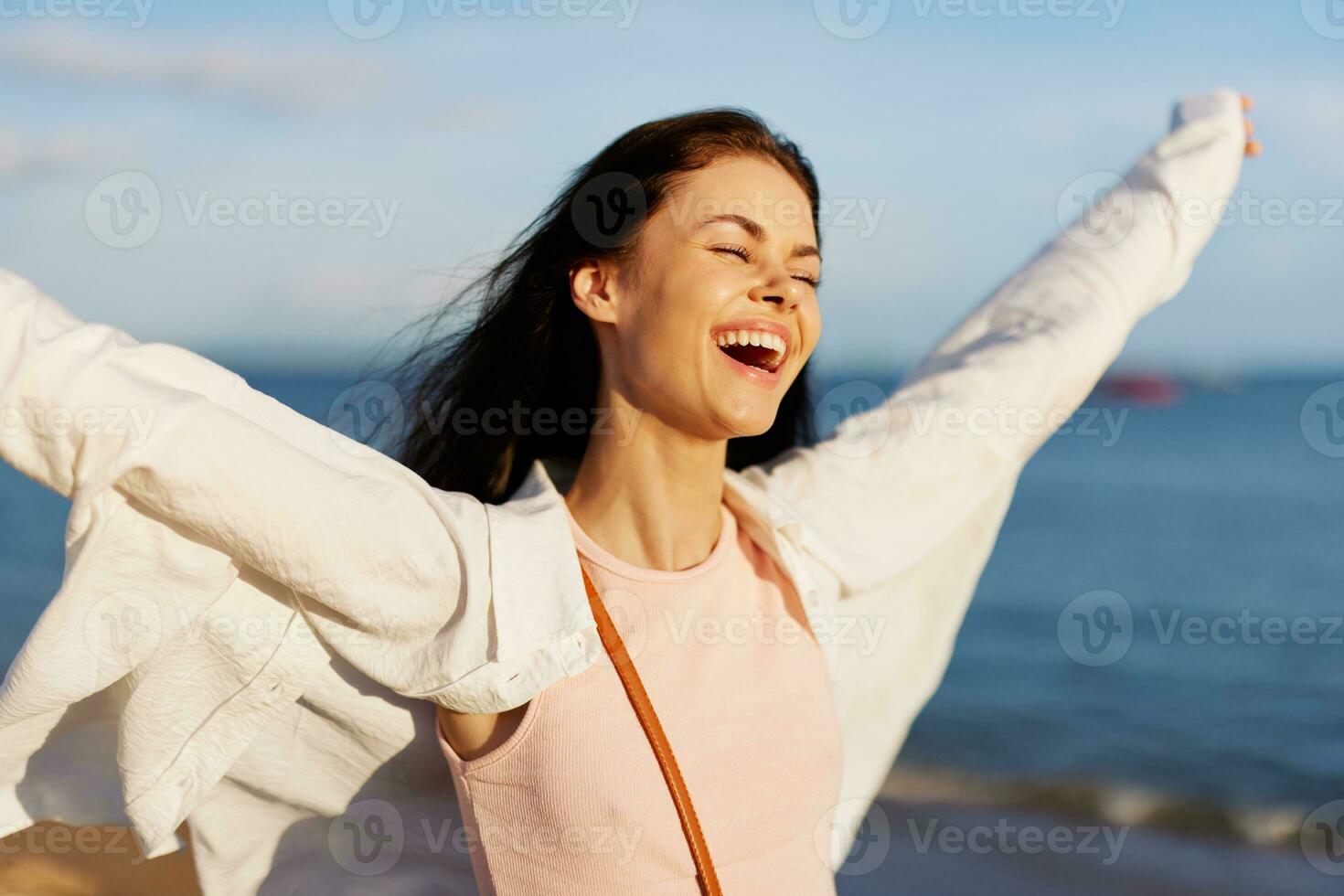 donna Sorridi con denti la libertà su vacanza a piedi su il spiaggia di il oceano nel bali tramonto, contento viaggio e rilassamento, tramonto luce, volante capelli, il concetto di modificare e emotivo Salute foto