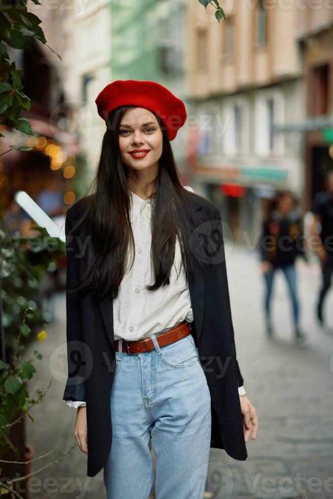 donna Sorridi moda modello passeggiate su il strada nel il città centro tra il folla nel un' giacca e rosso berretto e jeans, cinematico francese moda stile vestiario, viaggio per Istanbul primavera foto