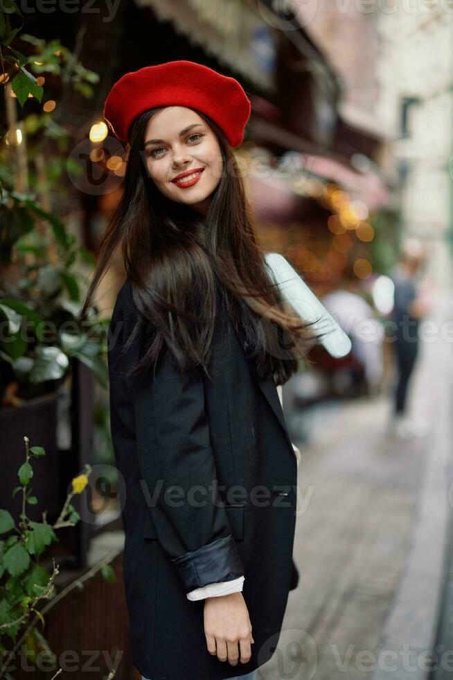 donna Sorridi moda modello passeggiate su il strada nel il città centro tra il folla nel un' giacca e rosso berretto e jeans, cinematico francese moda stile vestiario, viaggio per Istanbul primavera foto