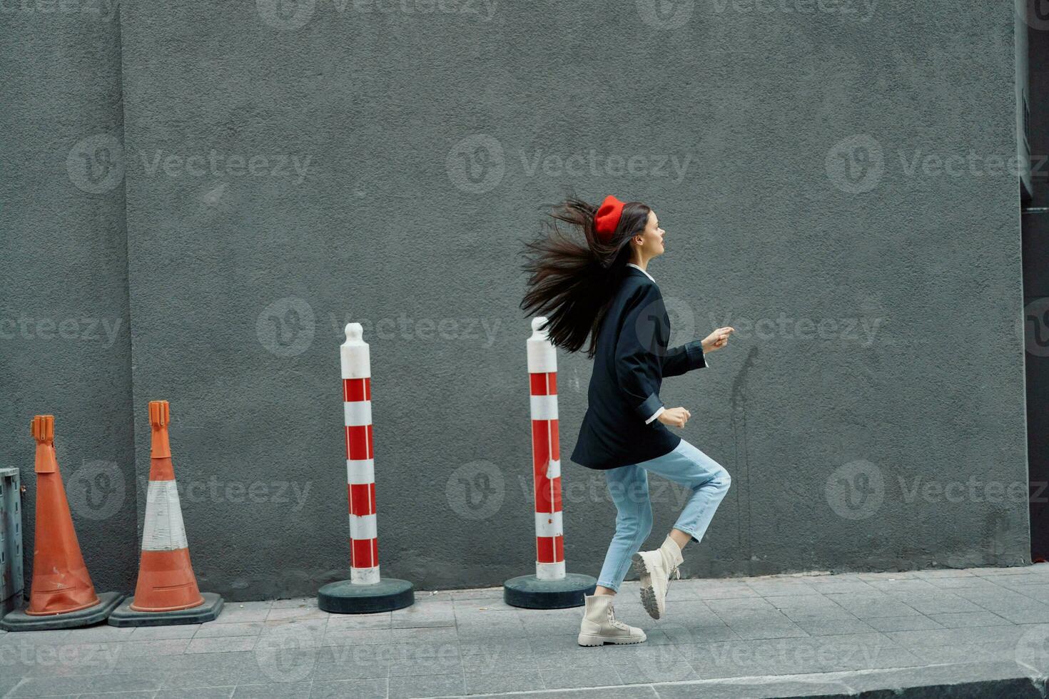 moda donna in esecuzione giù il strada nel davanti di il città turista nel elegante Abiti con rosso labbra e rosso berretto, viaggiare, cinematico colore, retrò Vintage ▾ stile. foto