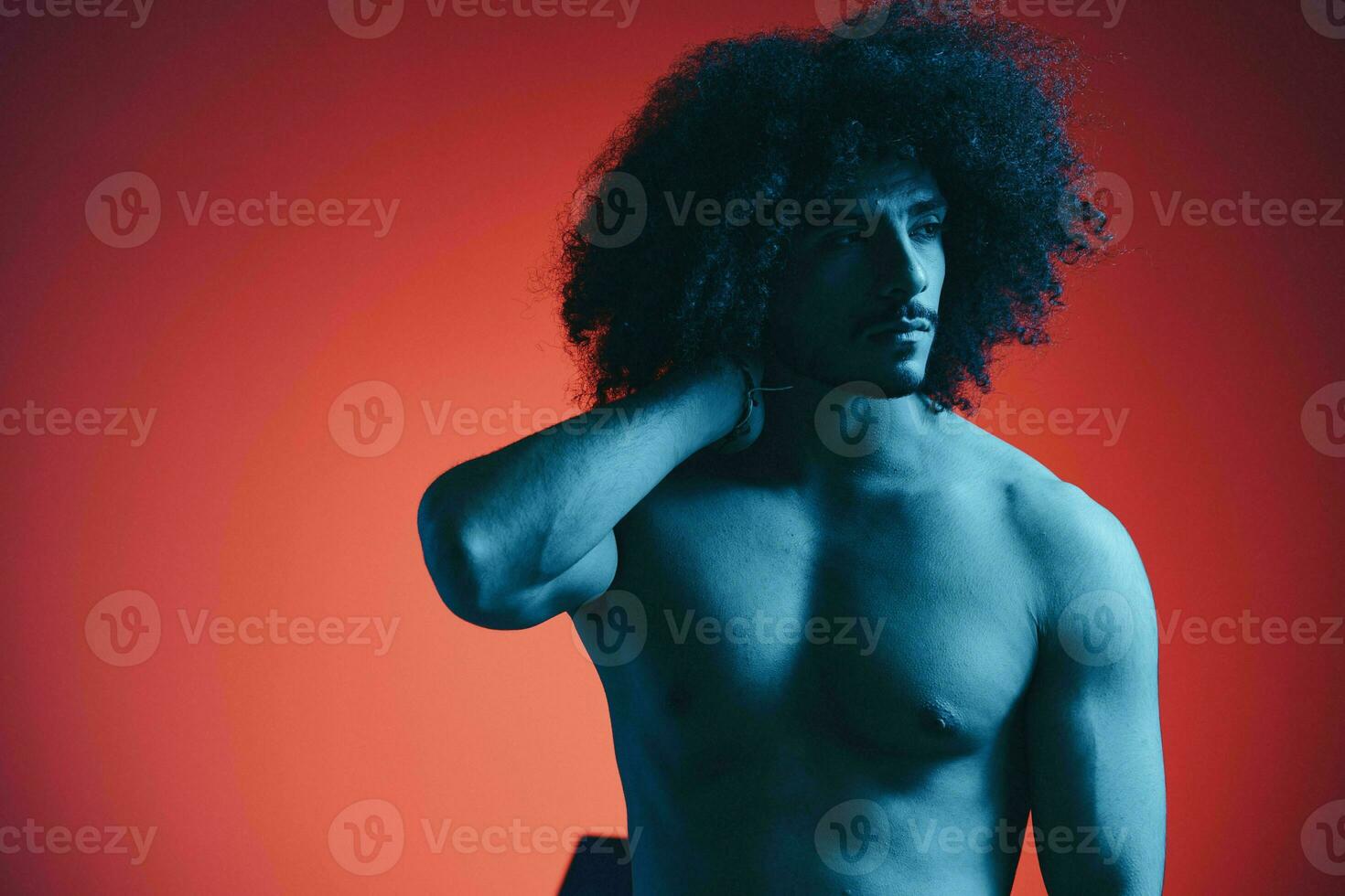 ritratto di moda uomo con Riccio capelli su rosso sfondo con elegante occhiali, multinazionale, colorato luce, nero pelle giacca tendenza, moderno concetto, sexy corpo. foto