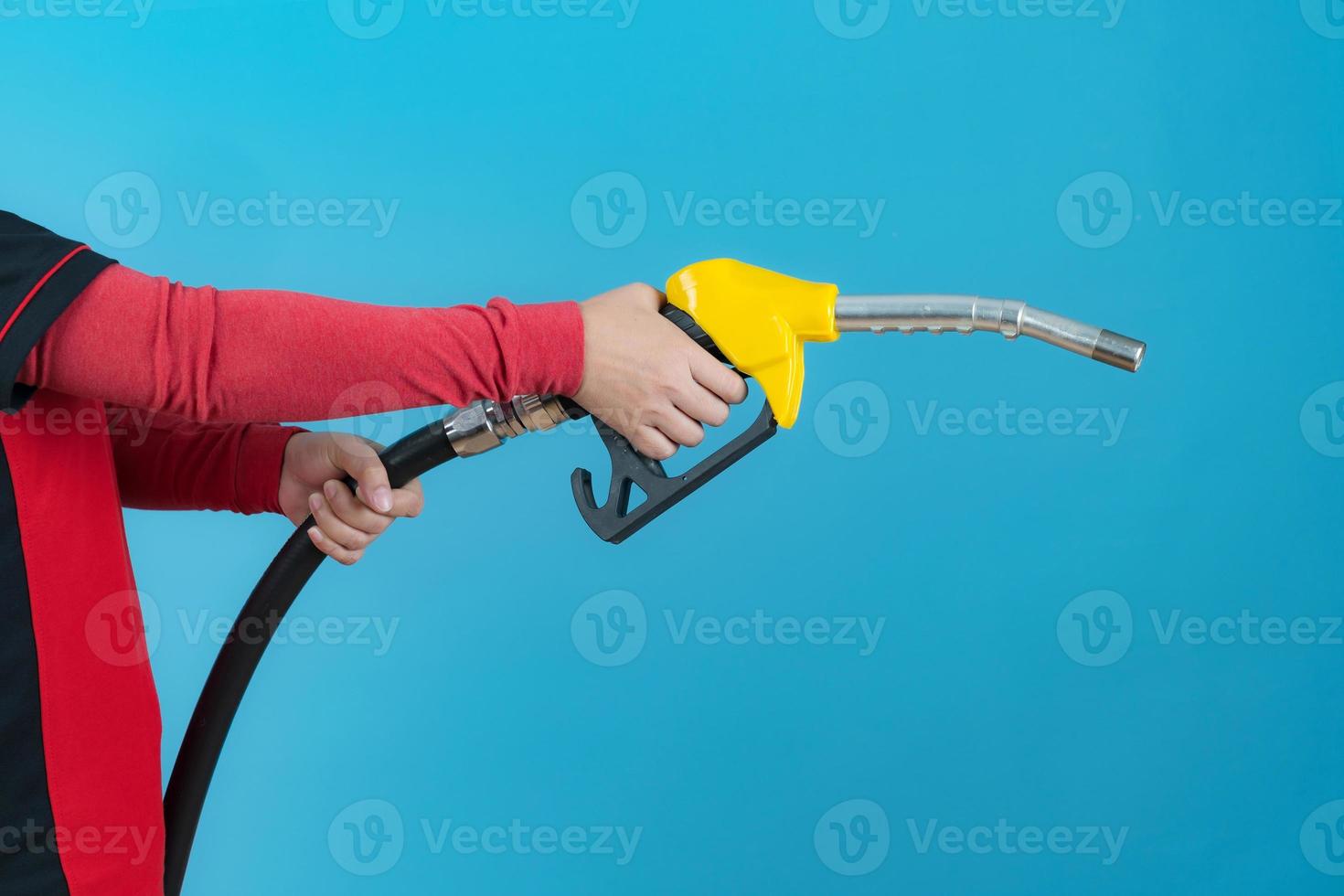 donna tenere l'ugello del carburante su sfondo blu foto
