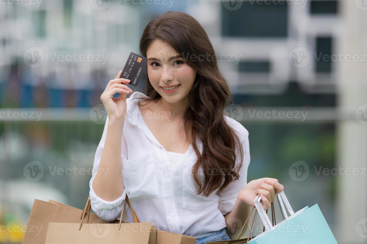 ritratto all'aperto di donna felice tenendo le borse della spesa e volto sorridente foto