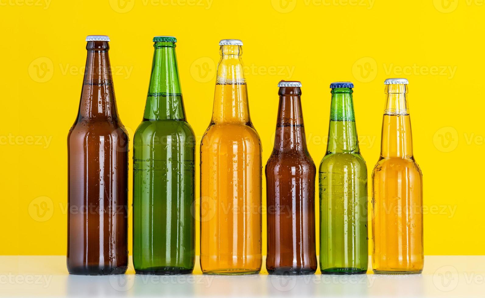 sei bottiglie di birra su uno sfondo giallo foto