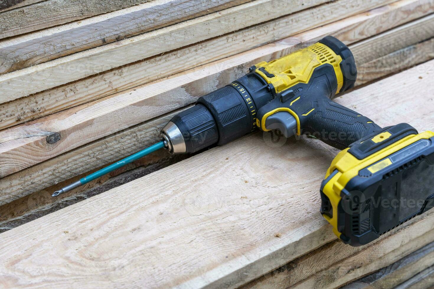 cordless Cacciavite dire bugie su un' pila di di legno tavole. costruzione foto