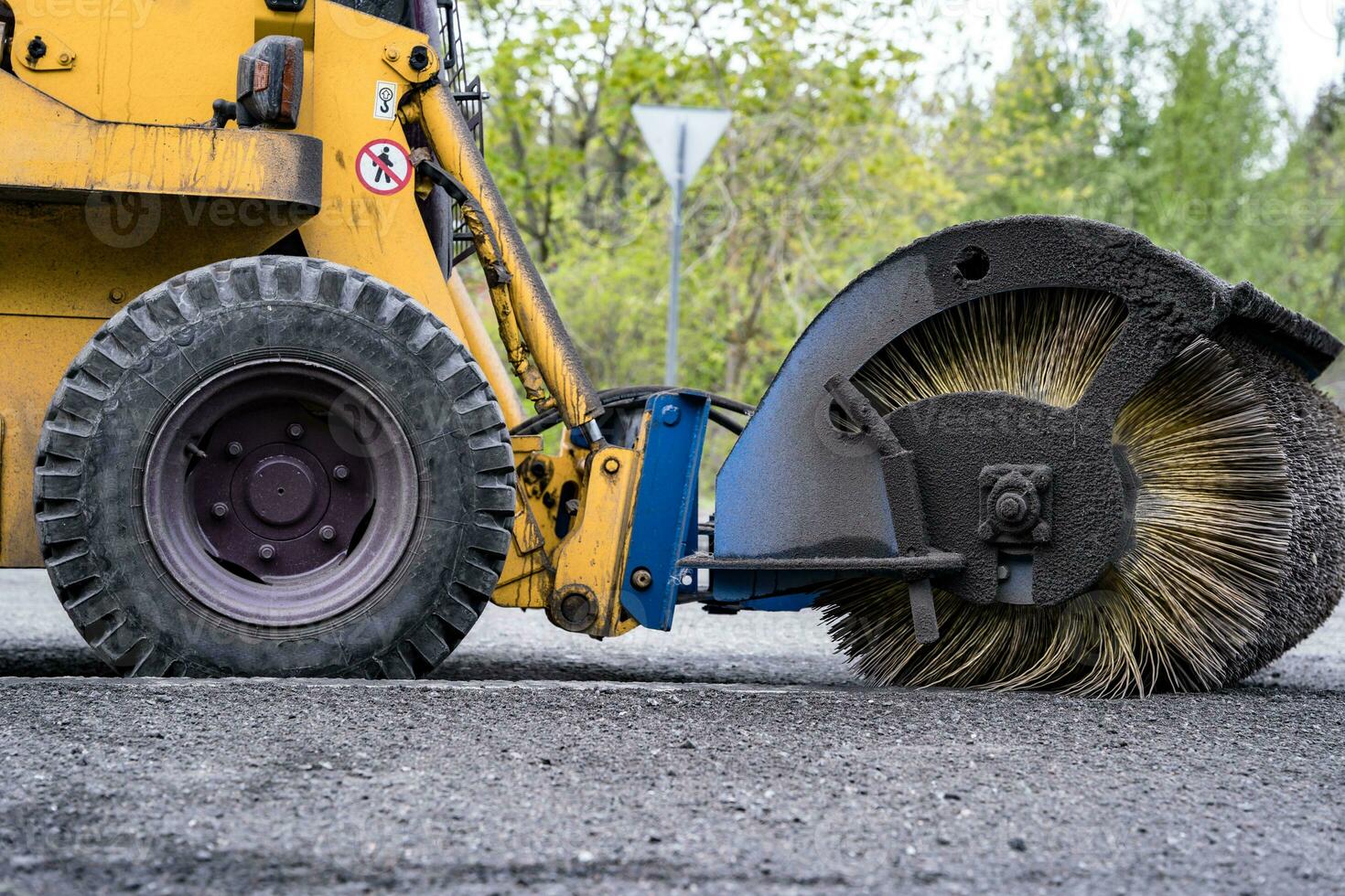 pulizia di spazzatura a partire dal il strada. un' rotante meccanico macchina spazzola foto