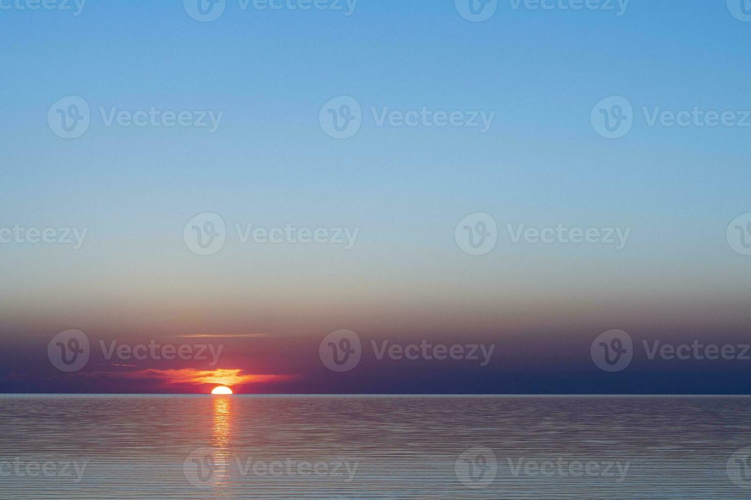 bellissimo rosso tramonto sole su il mare su il superficie di il acqua foto