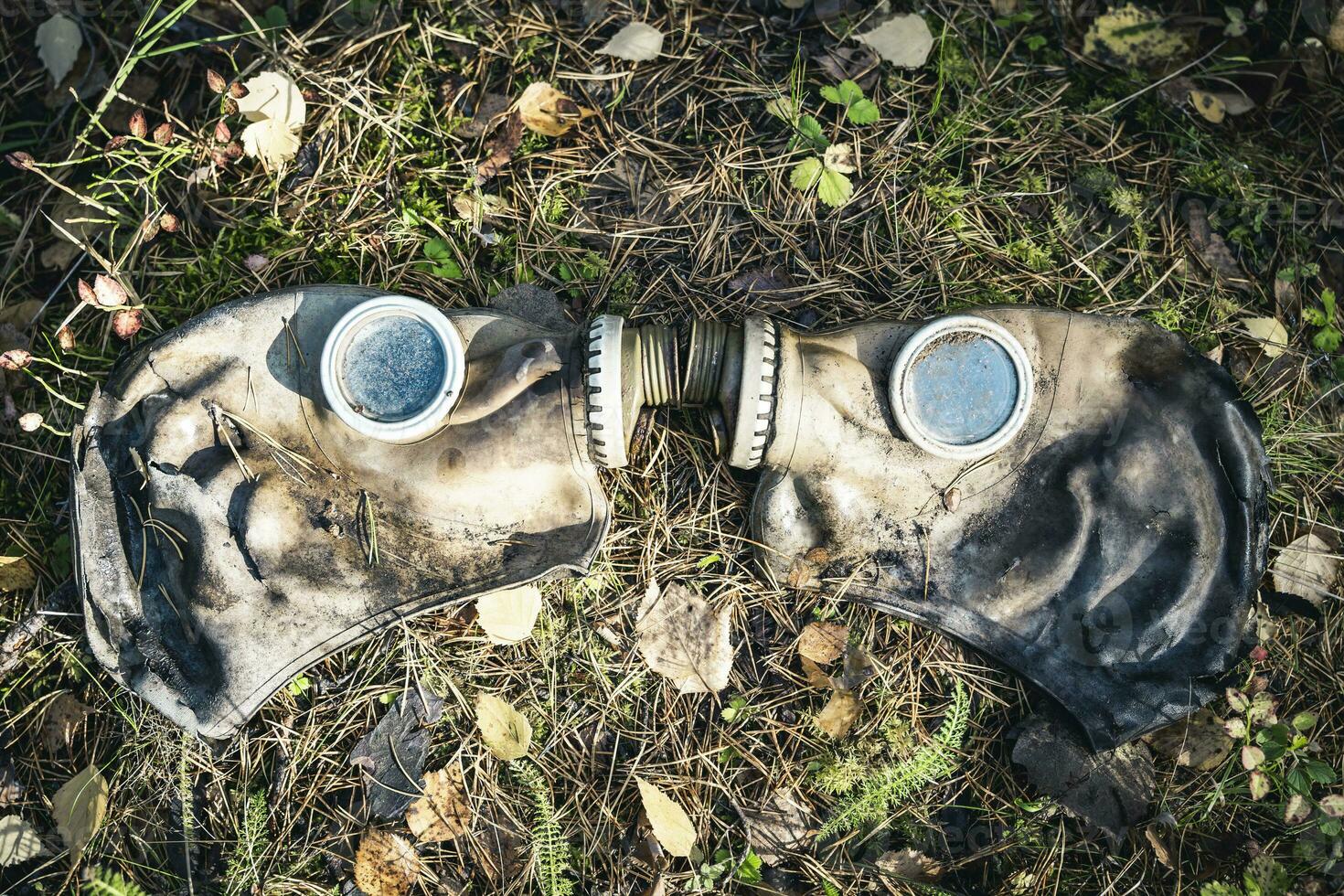 un vecchio Usato gas maschera dire bugie su il umido erba su il terra foto