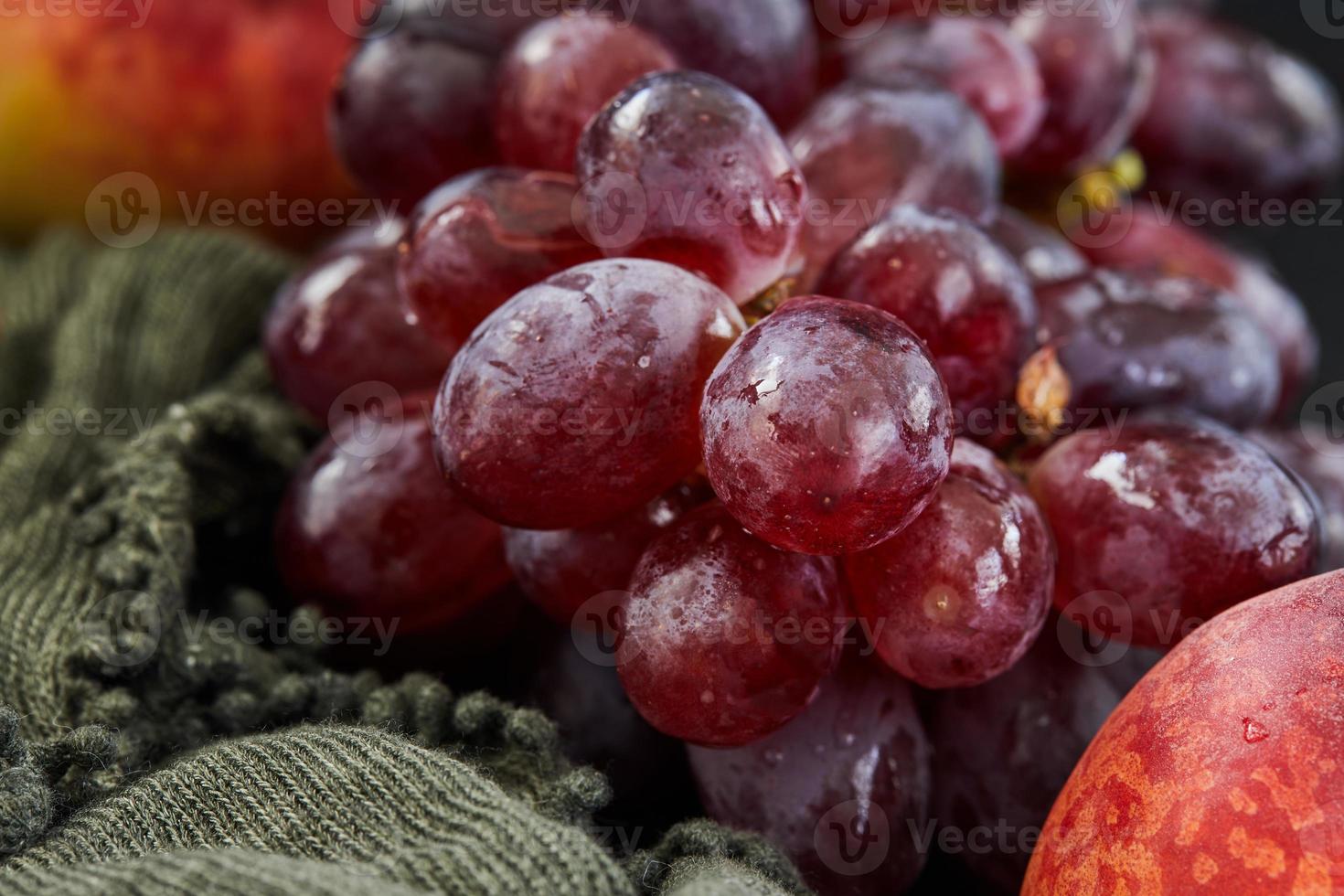 uva e pesche su uno sfondo scuro foto