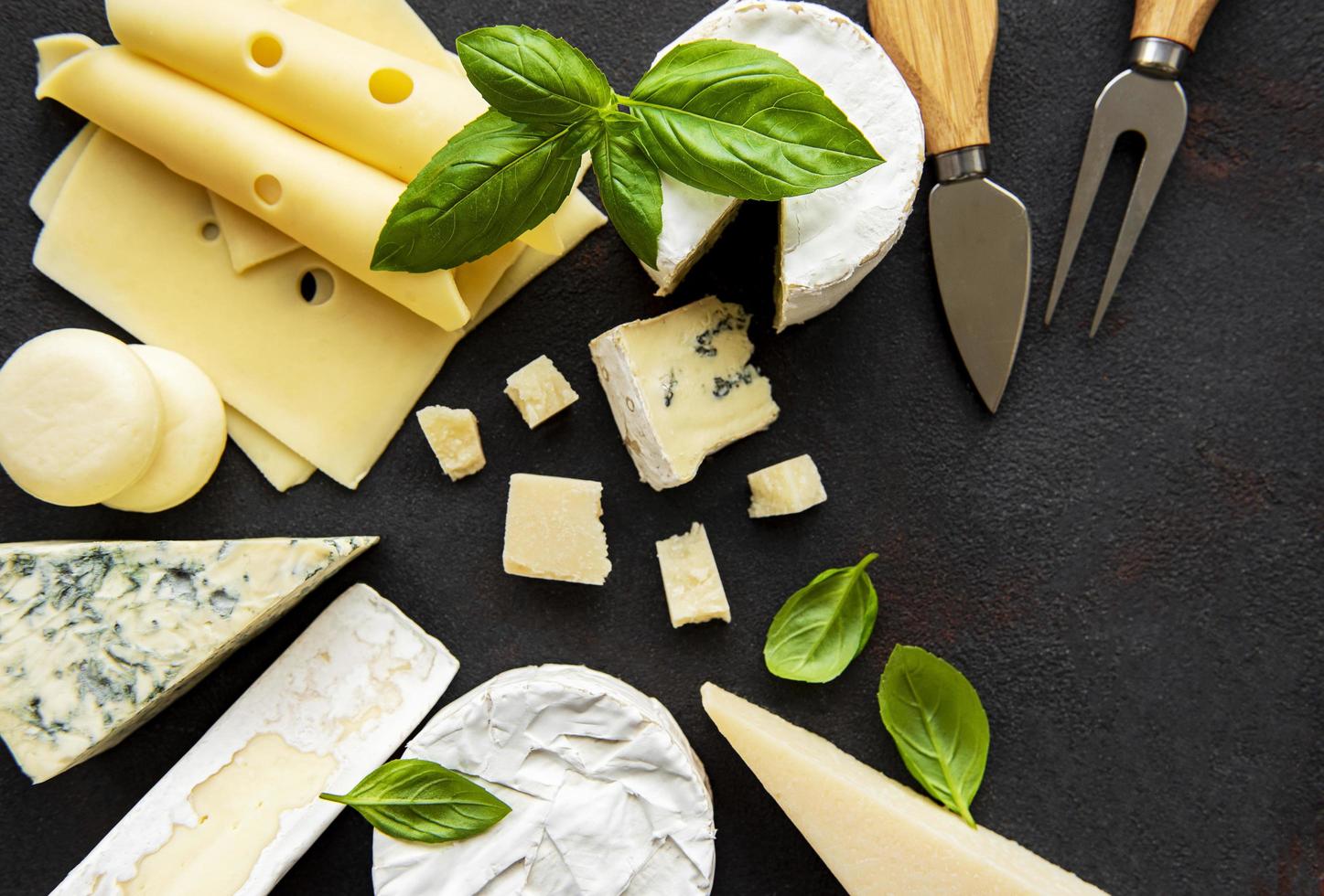 vari tipi di formaggio su uno sfondo di cemento nero foto