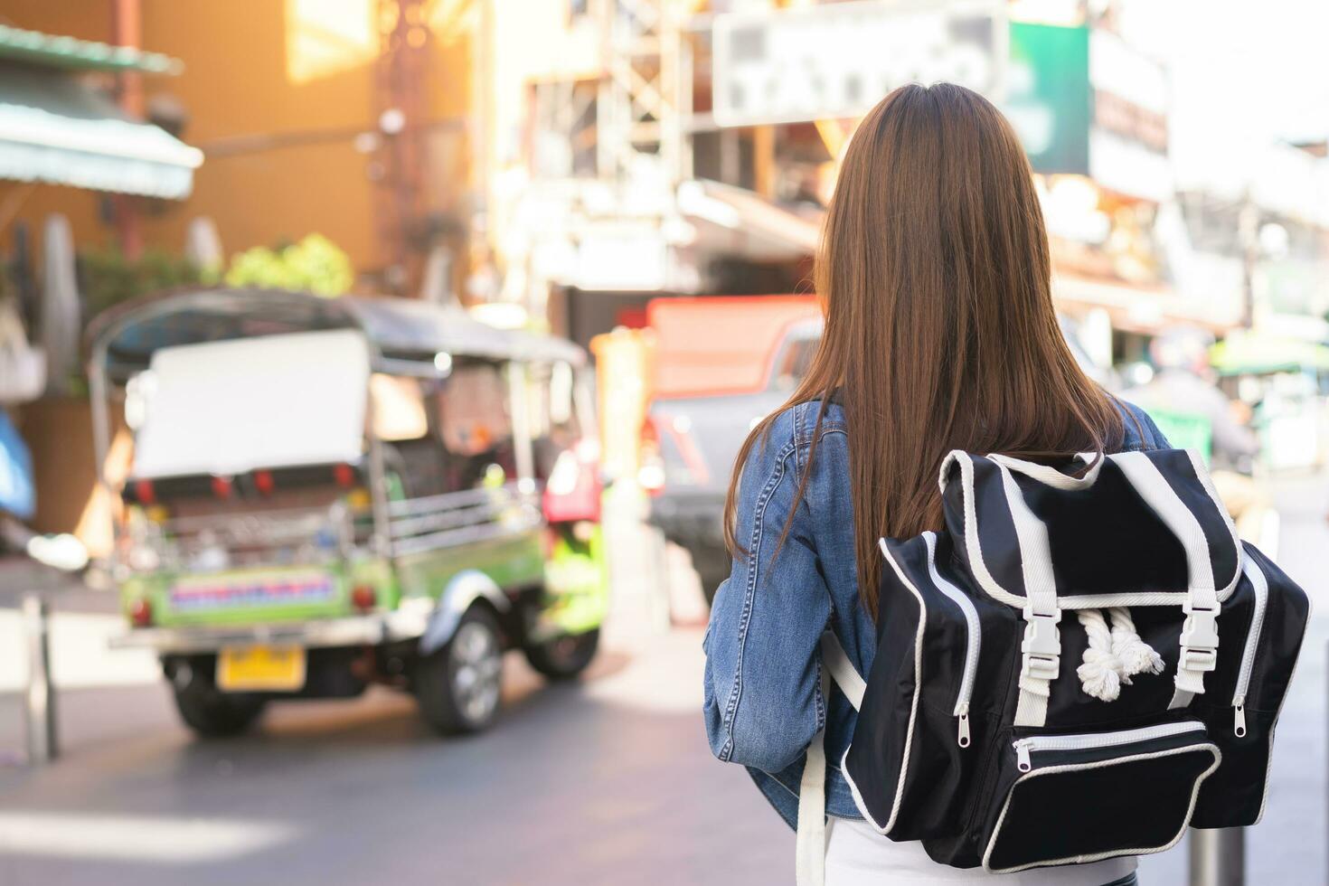 viaggiatore viaggio su vacanza fine settimana, vacanza nel estate, Sorridi bella asiatico giovane in viaggio donna zaino in spalla a partire dal dietro a o Indietro, a piedi nel khao san strada, strada all'aperto mercato, vita città nel bangkok. foto