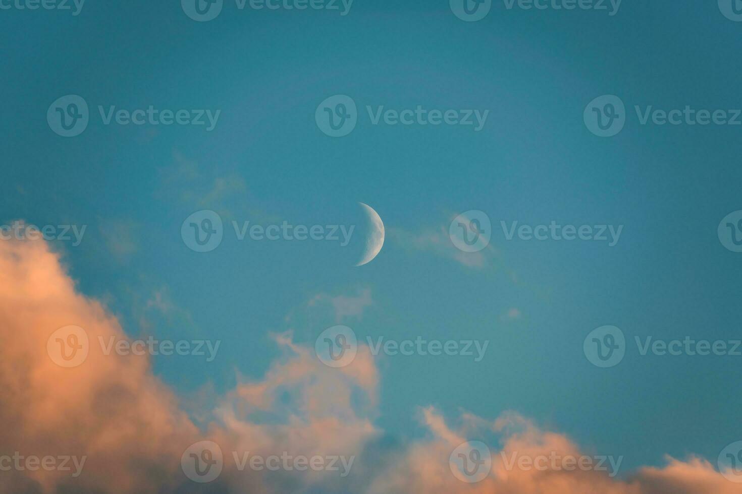mezzaluna Luna raggiante e sera nube su blu cielo foto