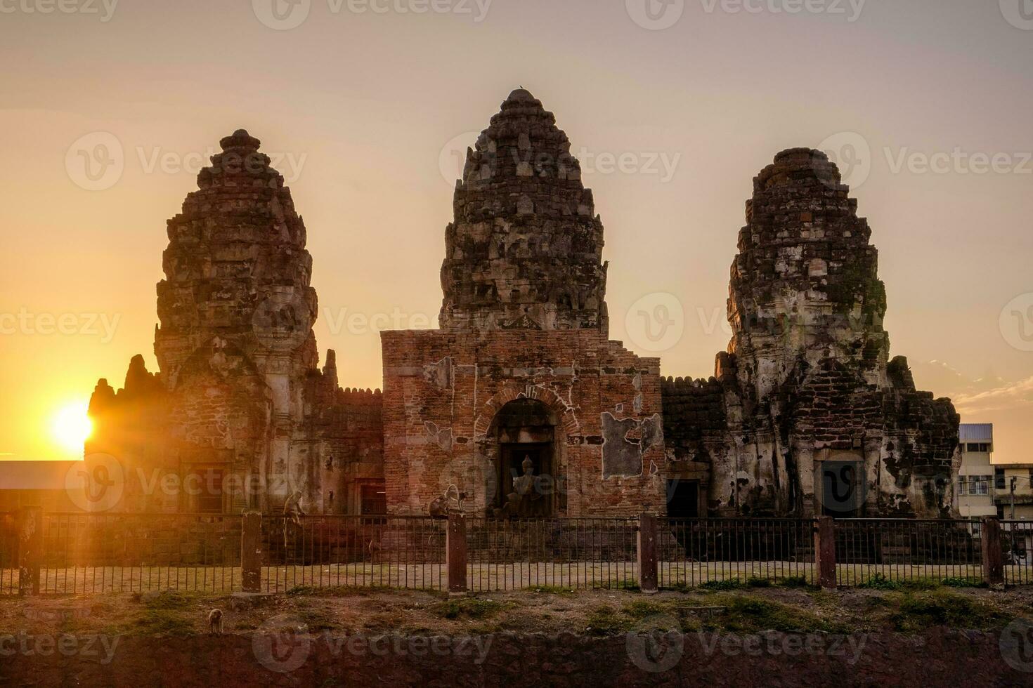 tramonto al di sopra di antico monumento, Phra Prang sam yot khmer stile con scimmia foto