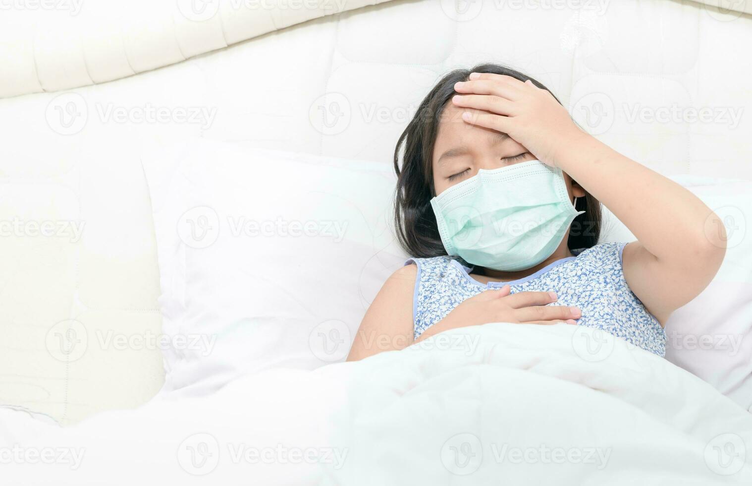 asiatico ragazza indossare chirurgico maschera ha un' alto febbre e male alla testa. foto