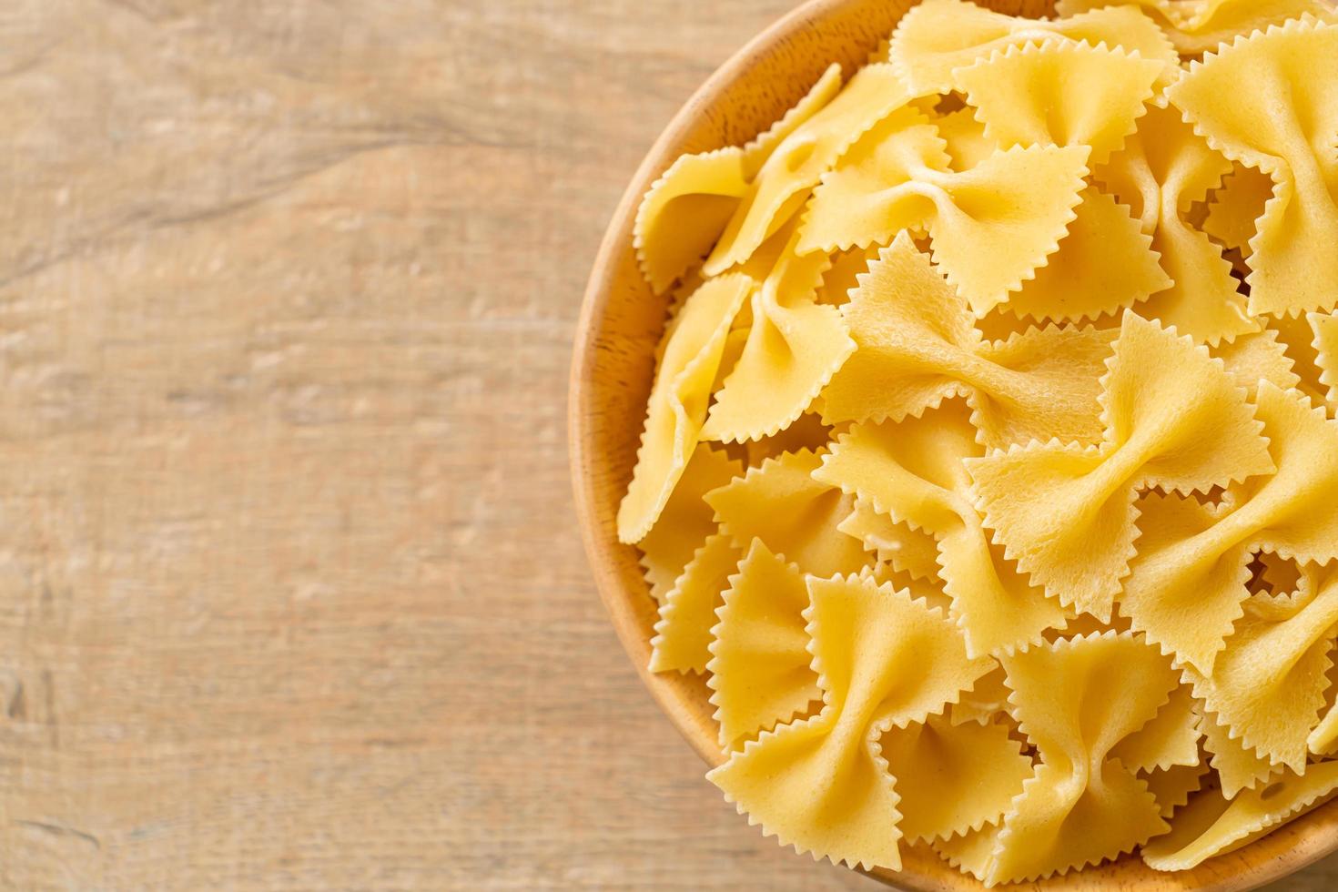 pasta secca di farfalle crude in una ciotola foto