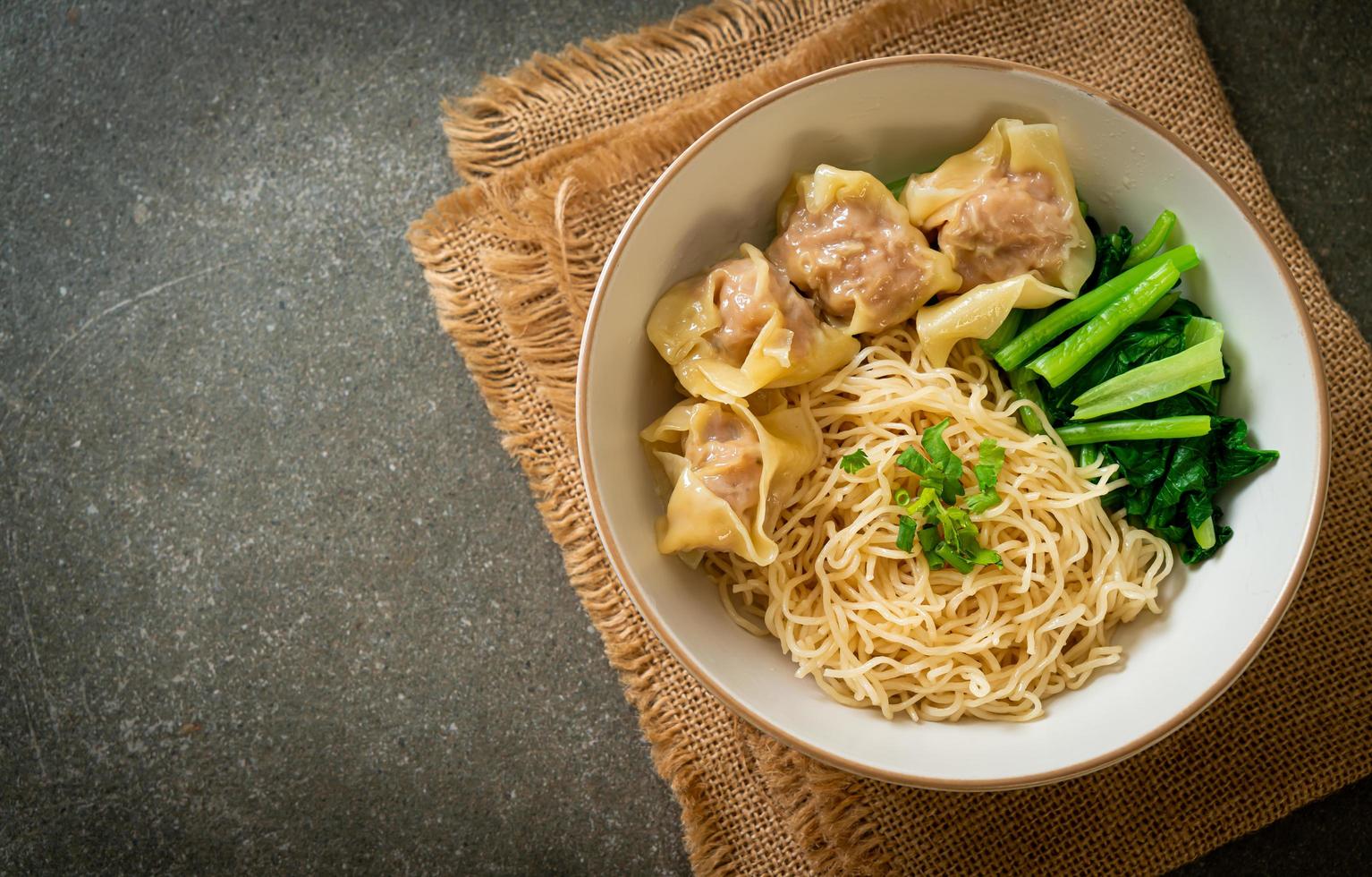 tagliatelle all'uovo essiccate con wonton di maiale o gnocchi di maiale senza zuppa - stile cibo asiatico foto