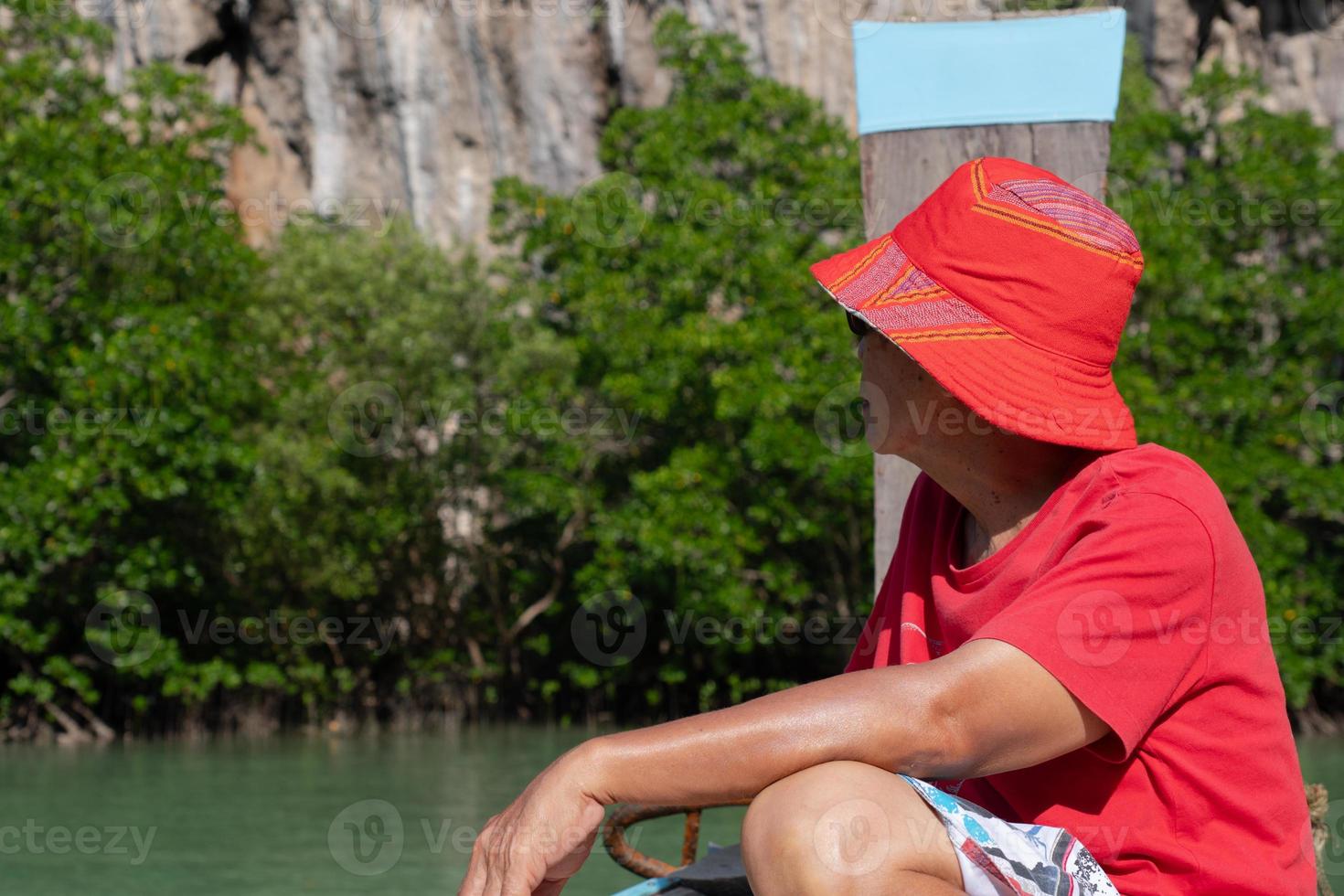 un uomo asiatico anziano viaggia su una barca a coda lunga per vedere la foresta di mangrovie durante le vacanze estive foto