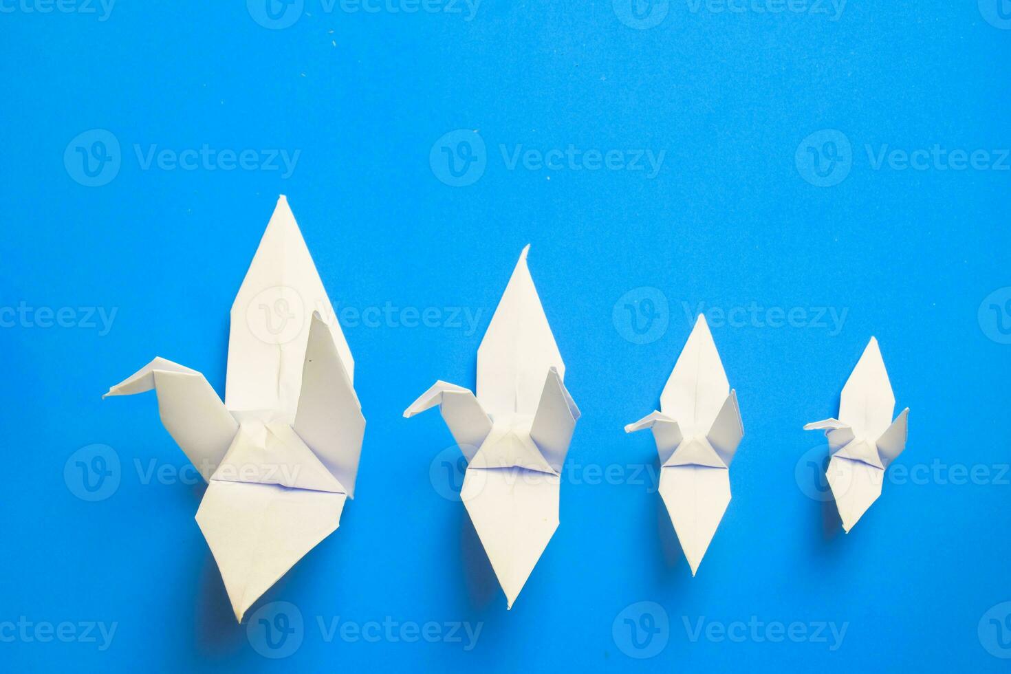 bianca uccello origami carta su blu sfondo. uccello pace, la libertà o opportunità concetto foto