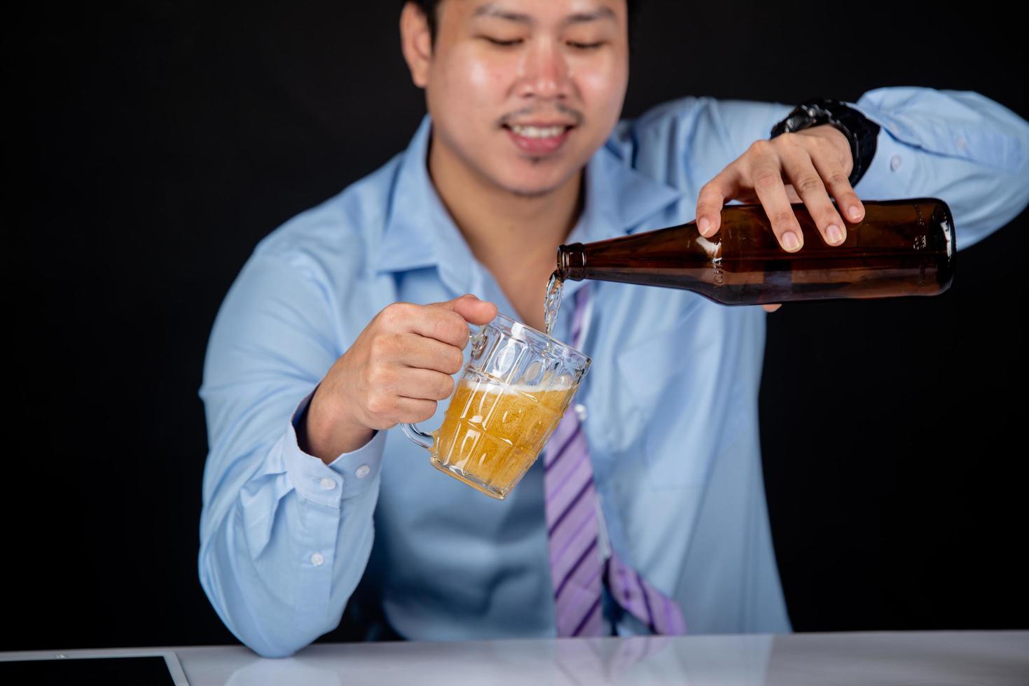 ritagliato primo piano di un uomo che beve birra a casa foto