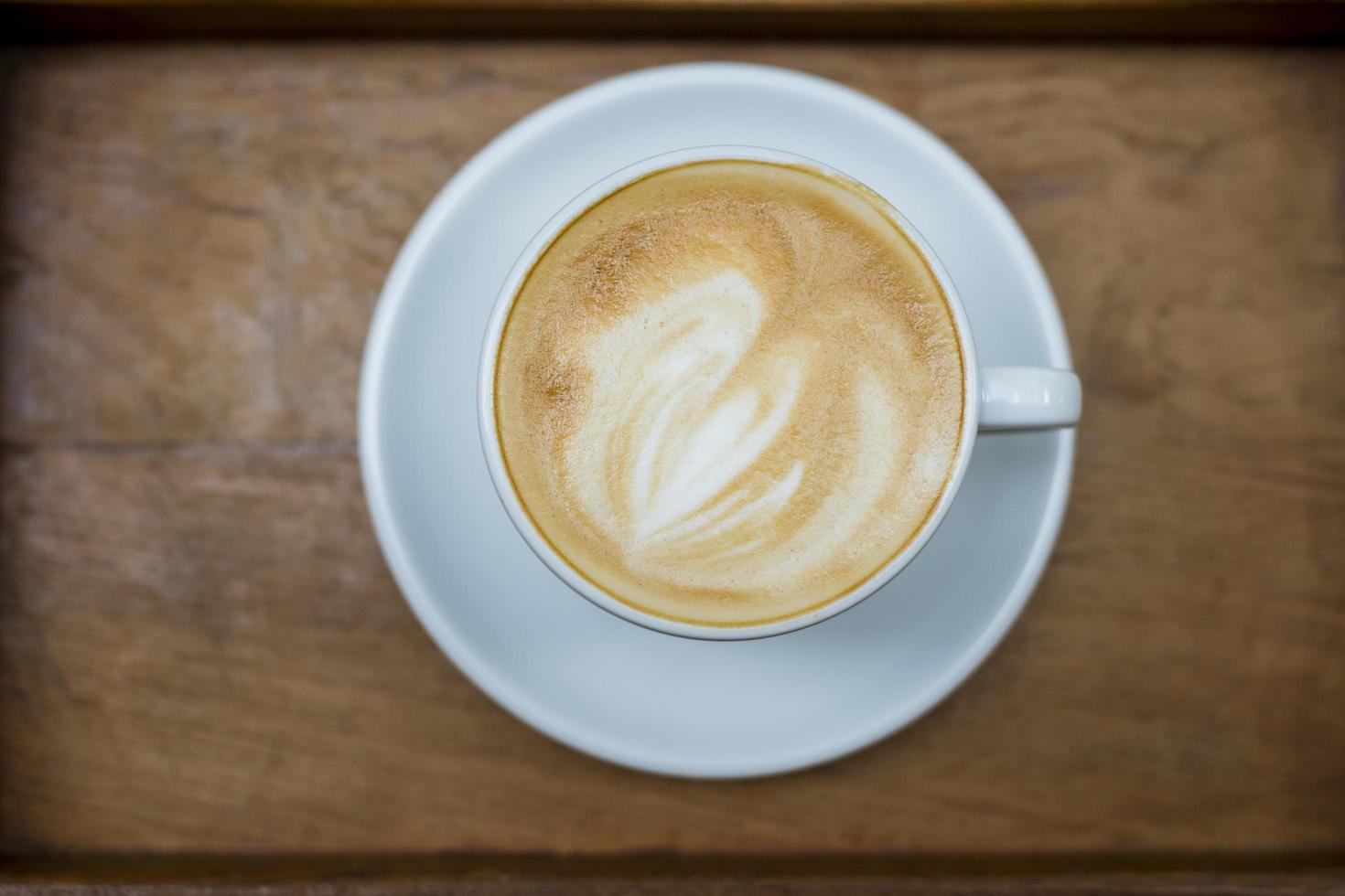 arte del latte caldo sullo sfondo del tavolo in legno foto