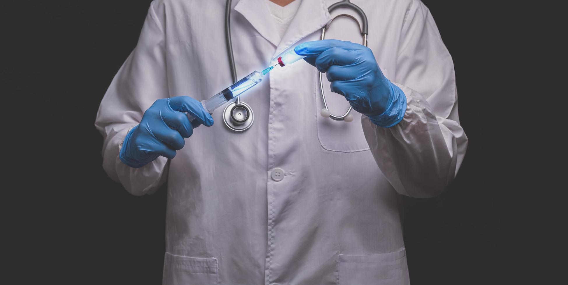 il dottore teneva una bottiglia di medicina per vaccini e una siringa medica foto