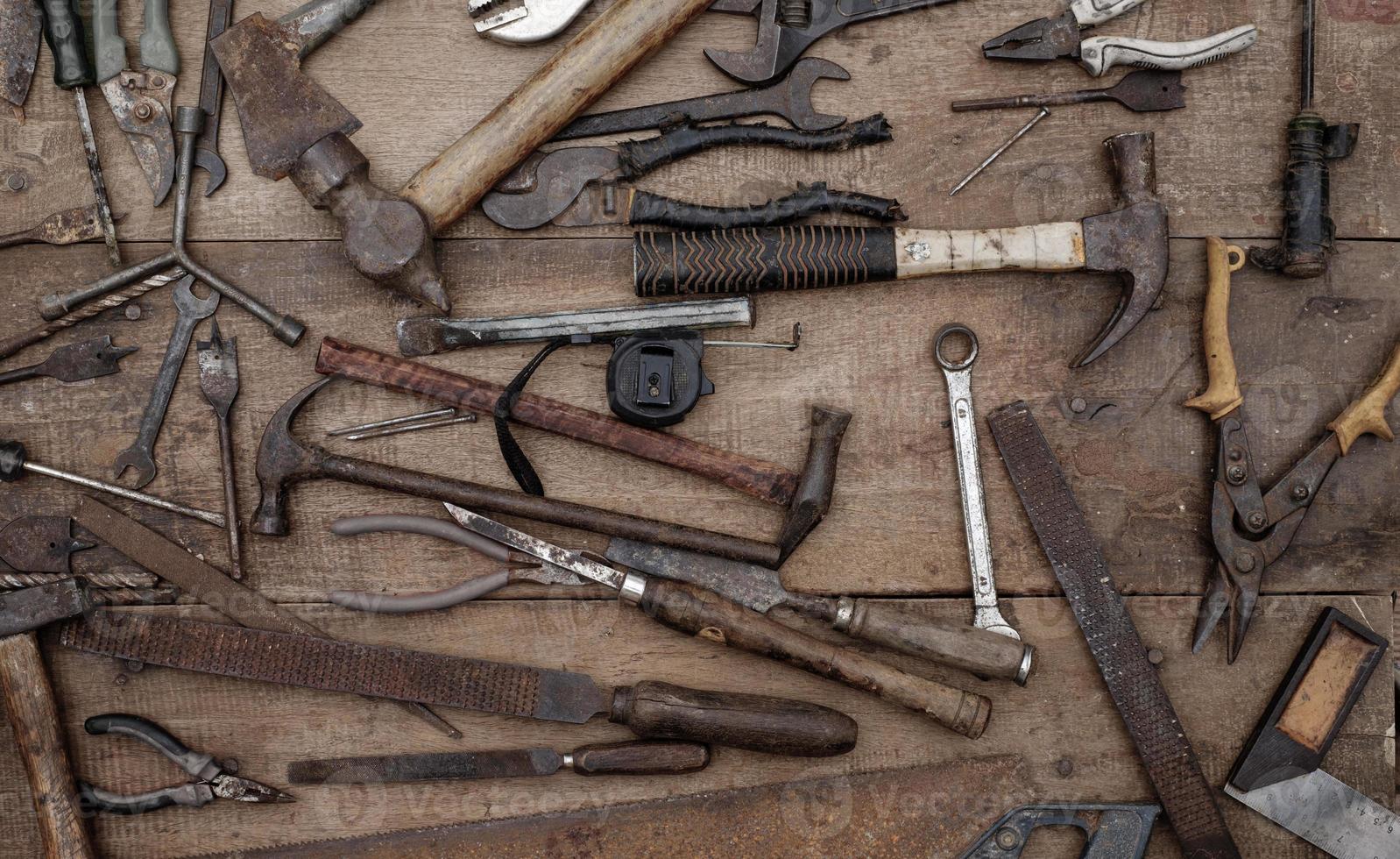 collezione di antichi utensili manuali per la lavorazione del legno su un banco da lavoro ruvido in legno vecchio foto