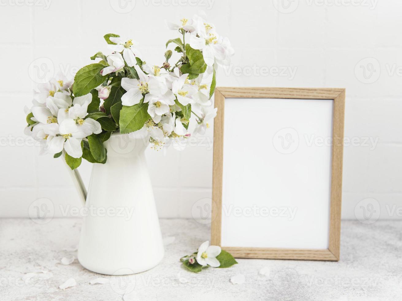 fiore di melo primaverile in un vaso con una cornice vuota foto