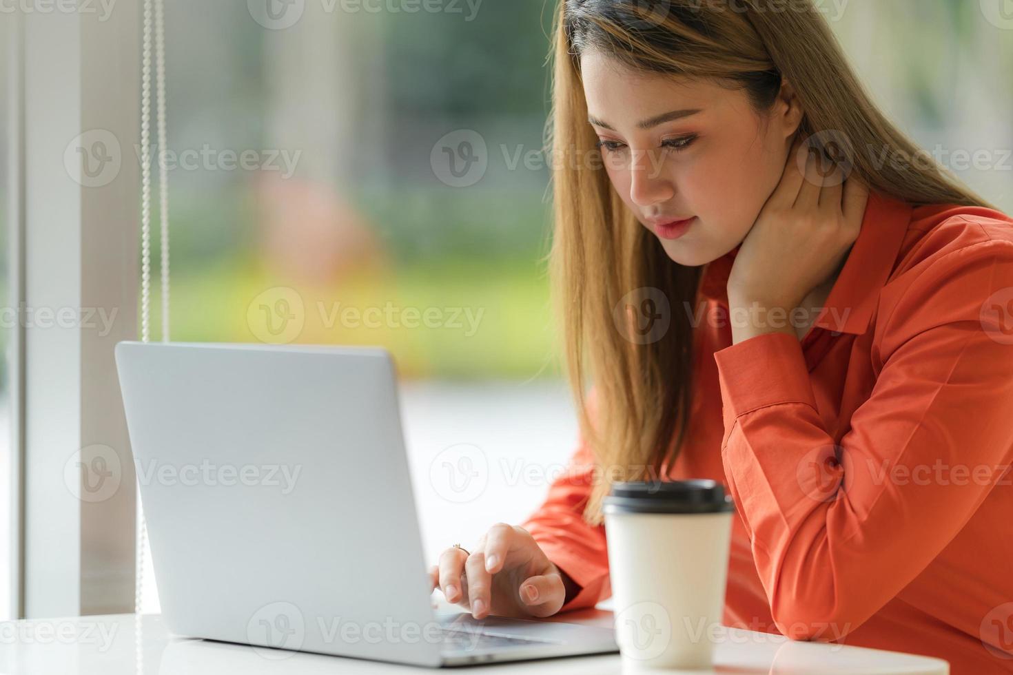 bella giovane donna che usa il computer portatile seduta su un bar foto