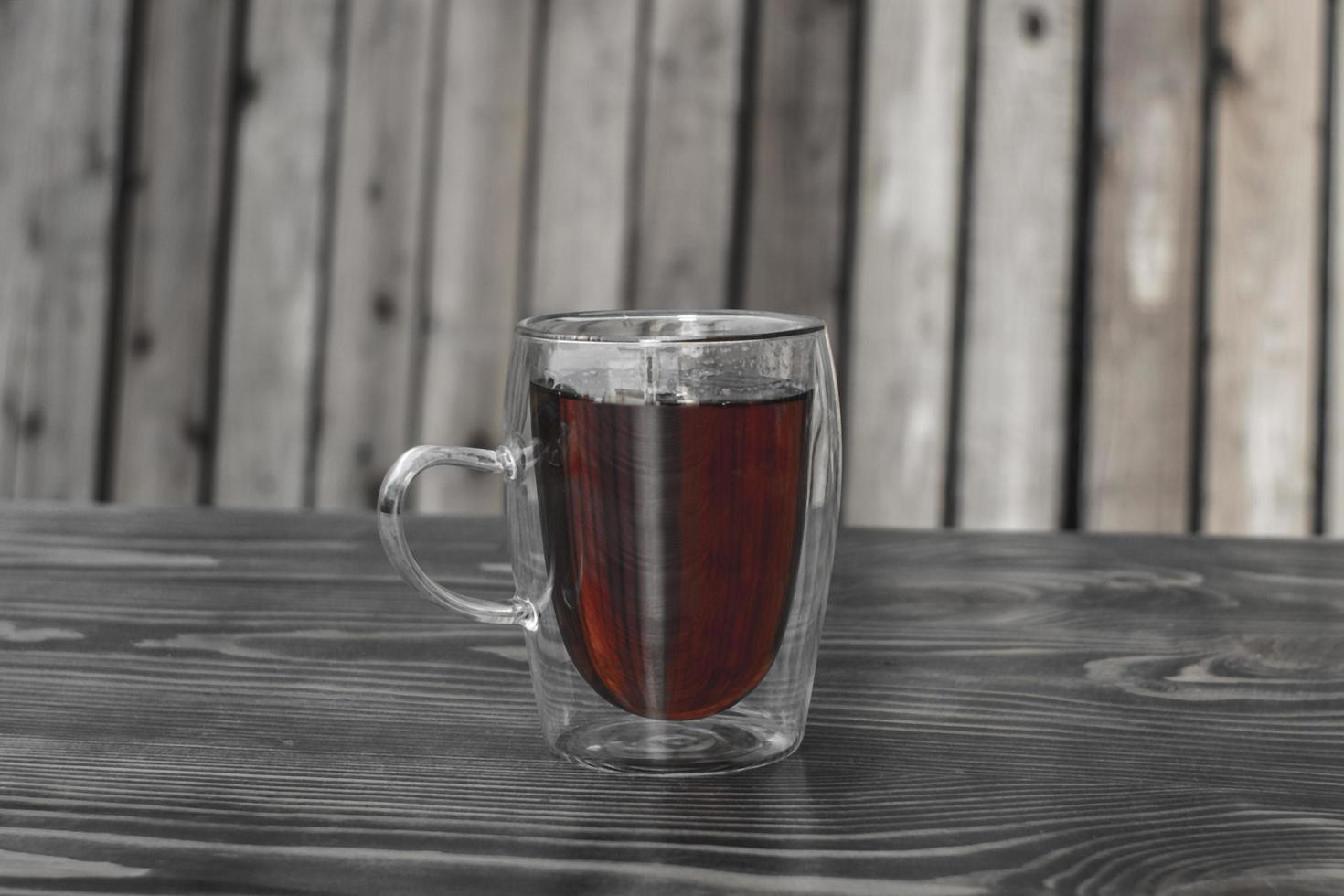 tazza di vetro con tè su un tavolo di legno foto