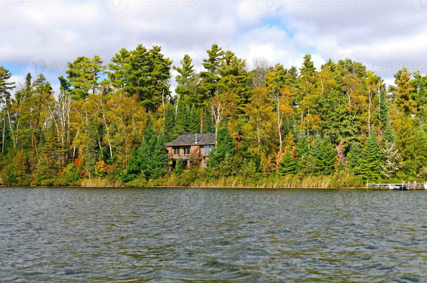 Casa su un' a distanza lago nel il autunno foto