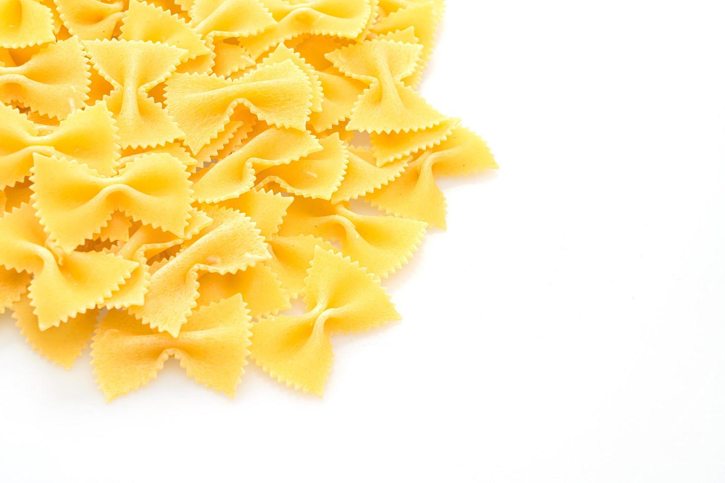 pasta secca di farfalle cruda su sfondo bianco foto