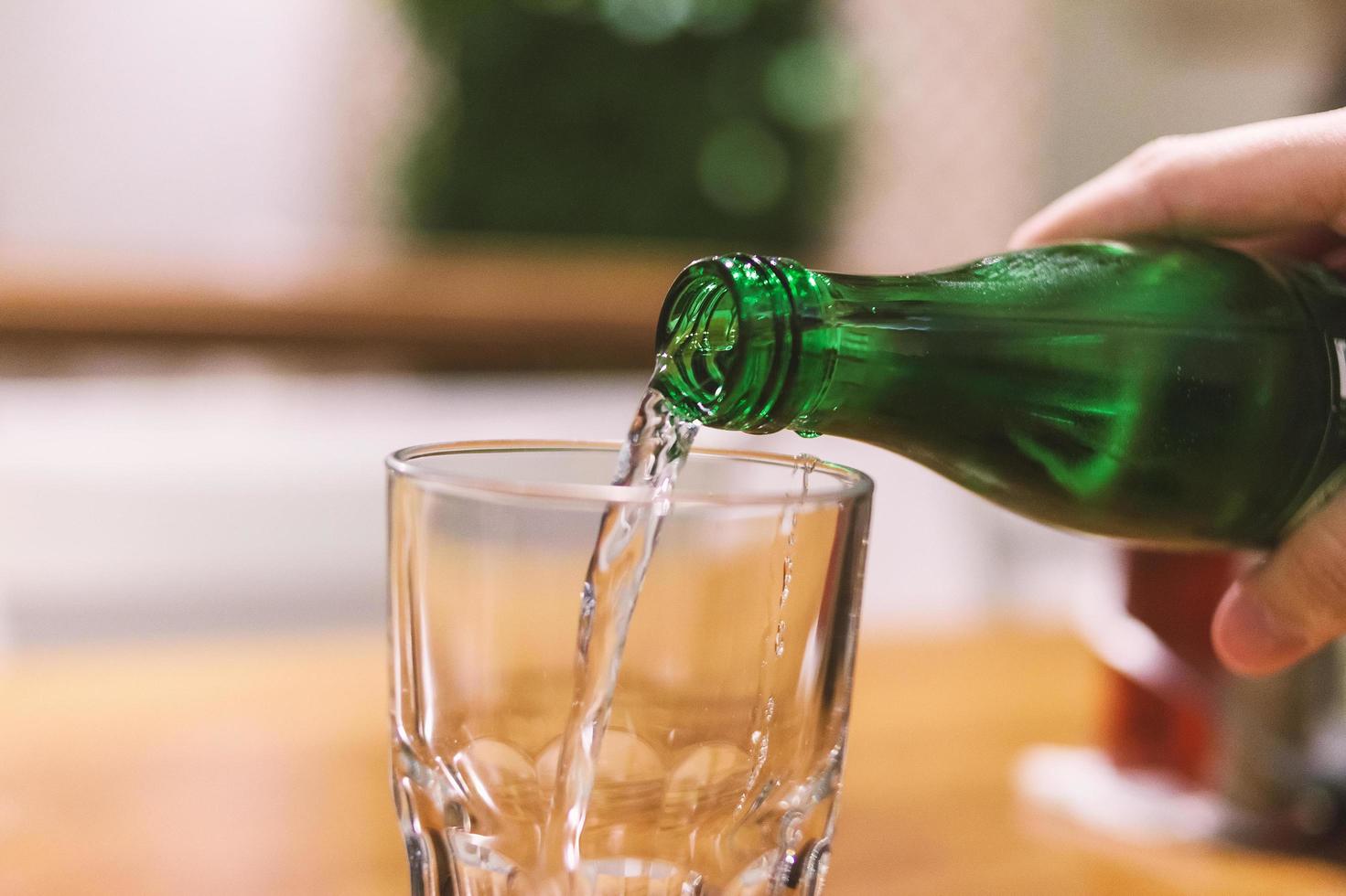 versando acqua minerale nel bicchiere foto