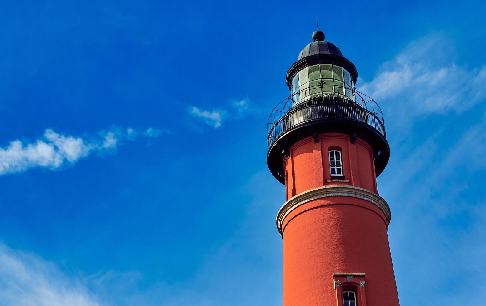 un faro sotto il cielo azzurro foto