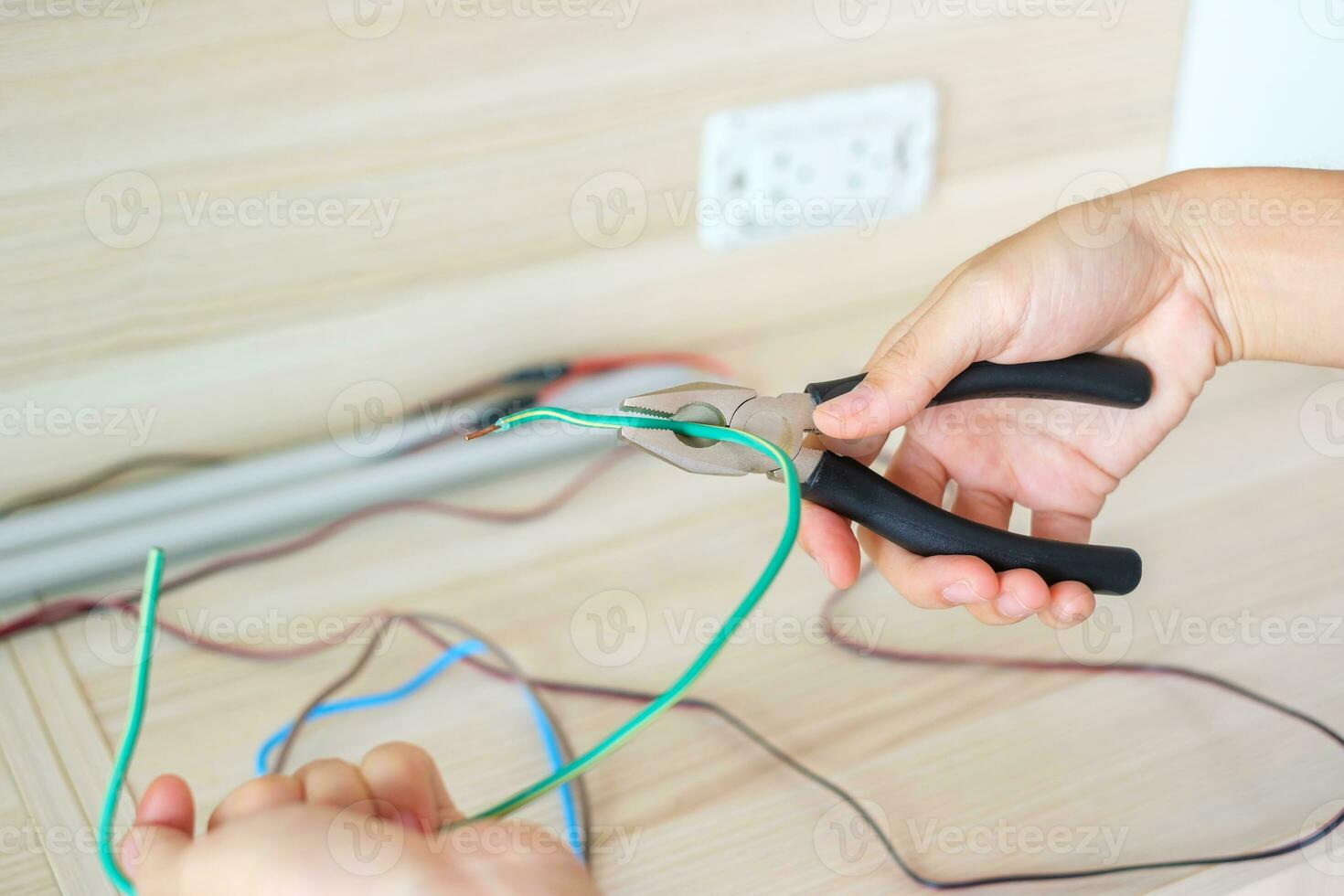 elettricista tagli elettrico fili con pinze, cablaggio cavi installazione per presa di corrente tappo. fissaggio, ristrutturazione, riparazione, servizio e sviluppo di casa e appartamento concetti foto