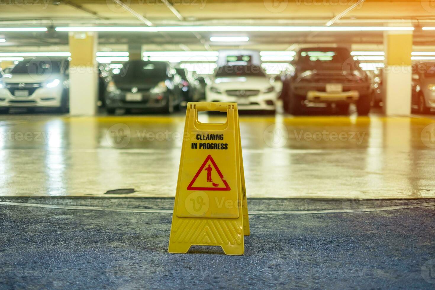 cartello mostrando avvertimento di attenzione bagnato pavimento nel box auto edificio foto