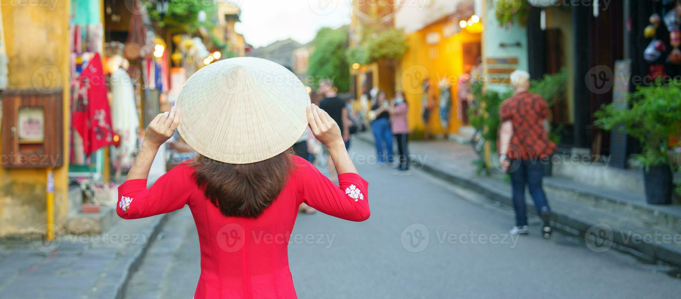 contento donna indossare ao dai vietnamita vestire, asiatico viaggiatore giro turistico a Hoi un antico cittadina nel centrale Vietnam. punto di riferimento e popolare per turista attrazioni. Vietnam e sud-est viaggio concetto foto