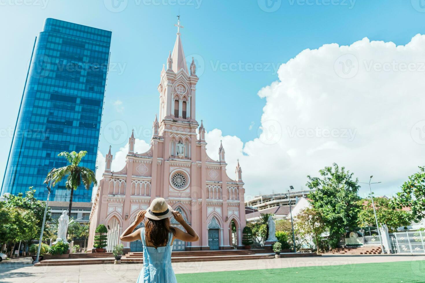 donna viaggiatore con blu vestito visitare nel da nang città. turista giro turistico il da nang Cattedrale Chiesa. punto di riferimento e popolare per turista attrazione. Vietnam e sud-est Asia viaggio concetto foto