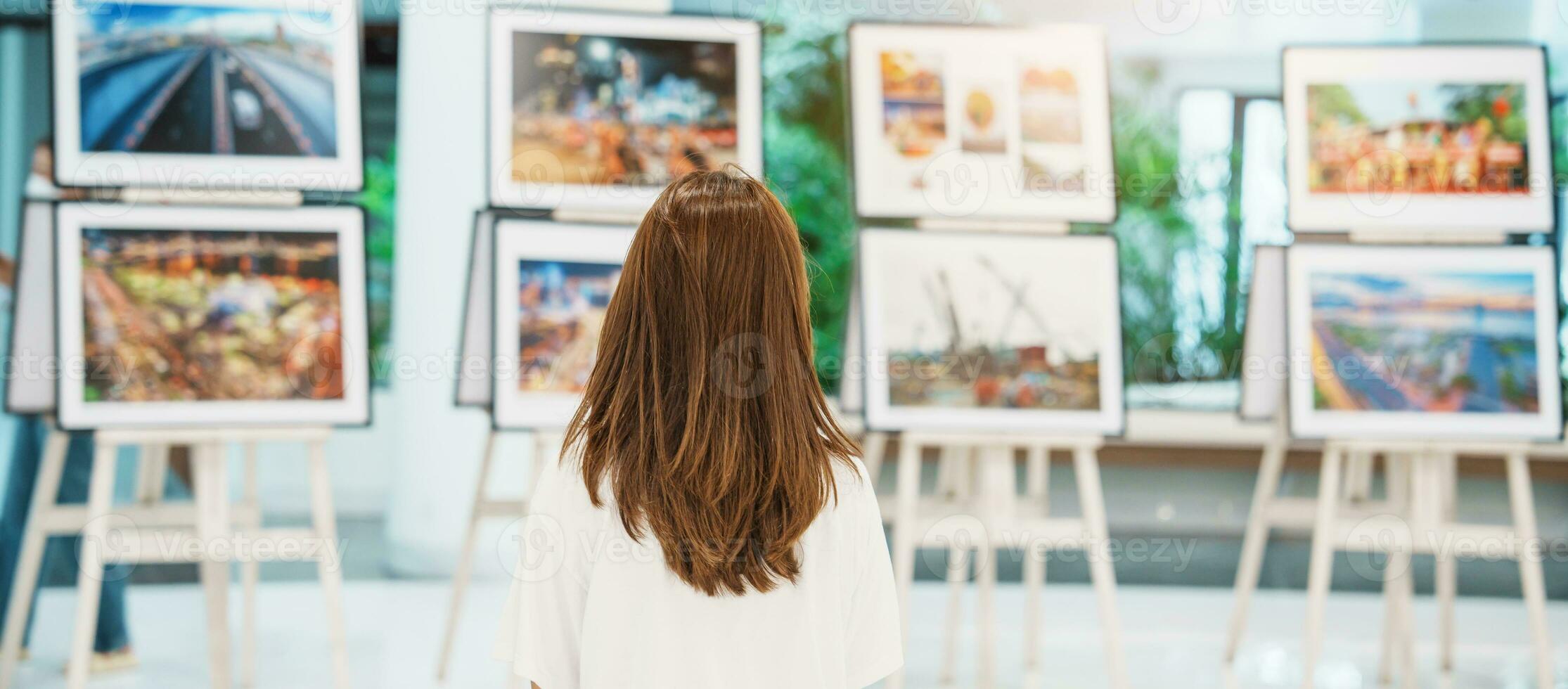 giovane femmina turista guardare galleria esposizione. arte , fotografia e Museo concetto foto