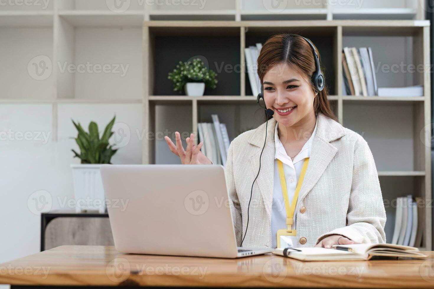 asiatico chiamata centro con cuffia e microfono Lavorando su sua il computer portatile. femmina operatore fornire eccezionale cliente servizio. supporto chiamata centro agente porzione cliente su inchiesta. entusiasta foto